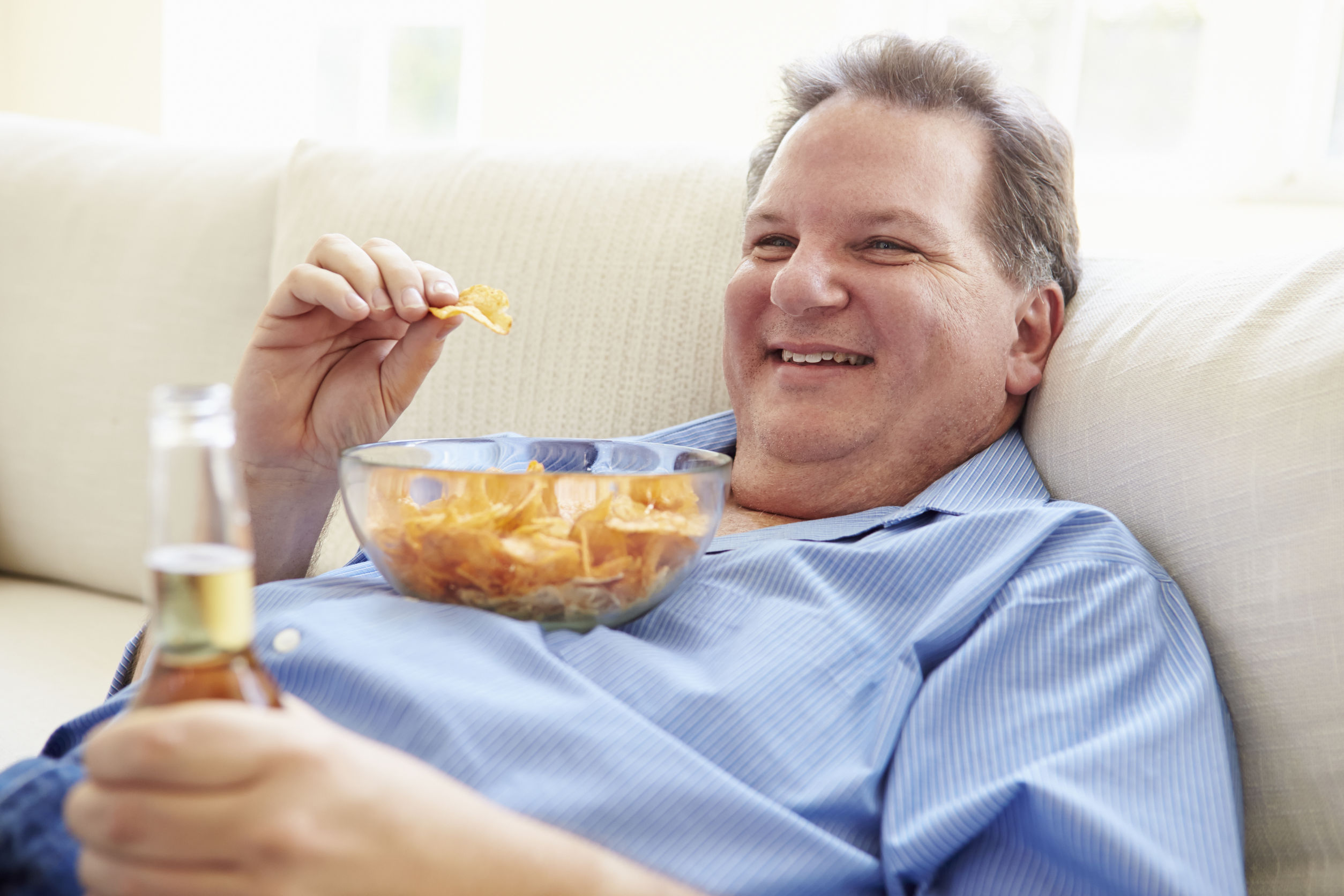 Bier, Chips und wenig Bewegung – der typische "Abend vor der Glotze" ist aus gesundheitstechnischer Sicht besonders für Personen mit erhöhtem Gewicht bedenklich. 